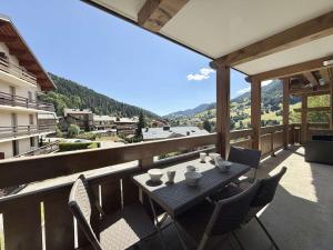 une table et des chaises sur un balcon avec vue dans l'établissement Appartement cosy à Flumet, 3 chambres, balcon sud, Wi-Fi, parking, près des pistes et navettes gratuites - FR-1-595-61, à Flumet