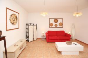 a living room with a red couch and a table at Roma 19 in Castelsardo