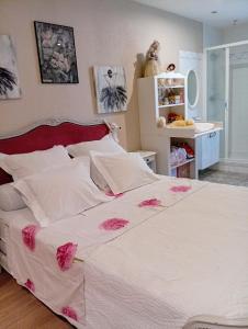 a bedroom with a large white bed with pink flowers at Chambre Romance in Pajay +3 photos