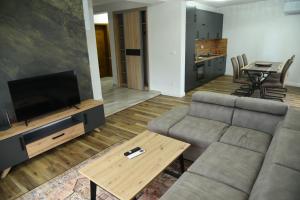 ein Wohnzimmer mit Sofa und Tisch in der Unterkunft Cattleya hotel in Plav