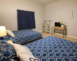 a bedroom with two beds and a desk with a television at Lake Travis Lakefront Retreat - Hot tub - Boat Ramp - Lakeside Parks in Lago Vista