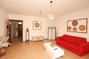 a living room with a red couch and a table at Roma 19 in Castelsardo +17 photos