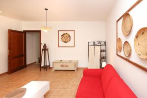 a living room with a red couch and a table at Roma 19 in Castelsardo