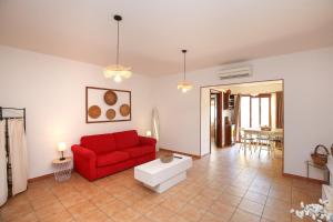 a living room with a red couch and a table at Roma 19 in Castelsardo