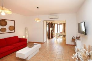 a living room with a red couch and a tv at Roma 19 in Castelsardo