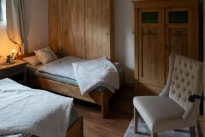 a bedroom with a bed and a chair at Blockhaus Vogelrast in Bad Lauterberg