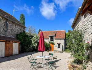 a patio with a table and chairs and an umbrella at annonce doublons HS in Le Vaudoué