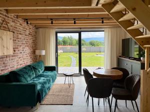 a living room with a green couch and a table at Pod Izerskim Niebem - kameralny domek z balią, w sąsiedztwie Świeradowa-Zdroju in Mroczkowice