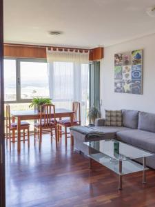ein Wohnzimmer mit Sofa und Tisch in der Unterkunft BaruHaus piscina y parking Rianxo x2 in Rianjo