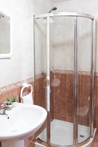 ein Badezimmer mit Dusche und Waschbecken in der Unterkunft BaruHaus piscina y parking Rianxo x2 in Rianjo
