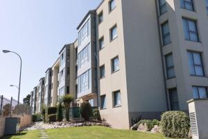 ein Mehrfamilienhaus mit einer Rasenfläche davor in der Unterkunft BaruHaus piscina y parking Rianxo x2 in Rianjo