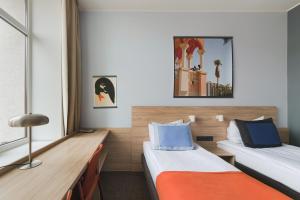 ein Hotelzimmer mit zwei Betten und einem Schreibtisch in der Unterkunft Corner Hotel in Vilnius
