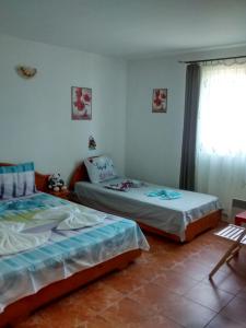 a bedroom with two beds and a window at Casa Carlo in Eforie Nord