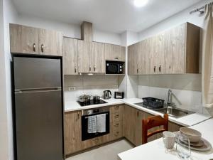 a kitchen with wooden cabinets and a stainless steel refrigerator at Your Second Home in Kefalos