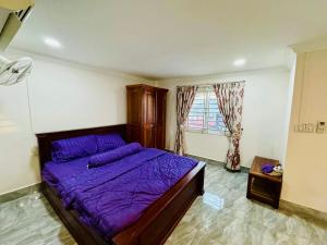 a bedroom with a purple bed and a window at TL Apartment, Cambodia in Phnom Penh +76 photos