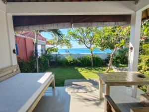 a patio with a table and a view of the ocean at Solaluna Beach Homestay in Amed