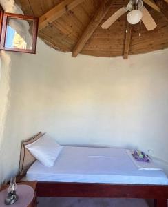 a bed in a room with a ceiling fan at Kolonjicha Dvori in Ivan Dolac