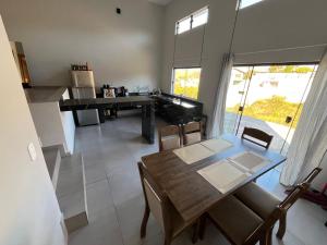 a kitchen and dining room with a table and a piano at Casa Jardim Primavera in Cunha