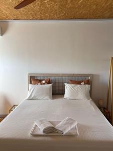 a bedroom with a bed with two towels on it at Himara Hostel in Himare