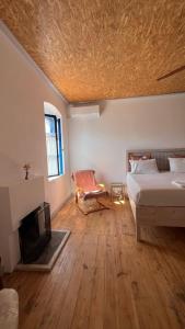 a living room with a bed and a fireplace at Himara Hostel in Himare