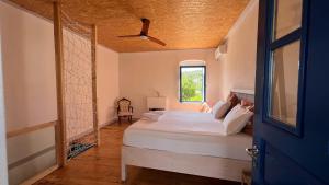 a bedroom with a bed and a ceiling fan at Himara Hostel in Himare
