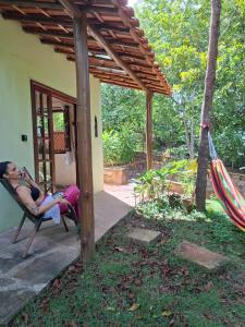伦索伊斯Casóca的一位女士坐在房子外面的吊床上。