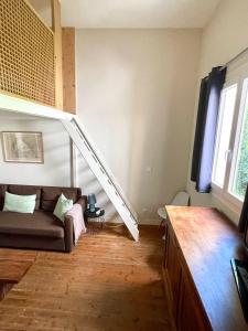 un salon avec un canapé et un escalier dans l'établissement Arcachon, quartier historique, Maison de ville à 2 pas de la plage, à Arcachon