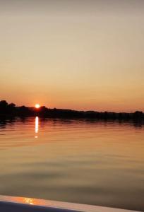 a sunset on the water with a boat at Home between lakes in Mattsee