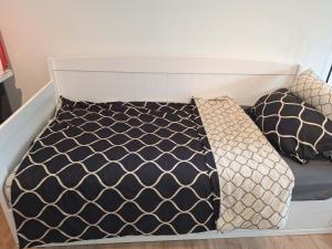 a bed with black and white sheets and pillows at Home between lakes in Mattsee