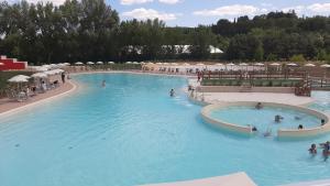 a large swimming pool with people in the water at Le Cupe in Corciano