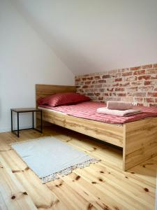 a bed in a room with a brick wall at Pod Izerskim Niebem - kameralny domek z balią, w sąsiedztwie Świeradowa-Zdroju in Mroczkowice +55 photos