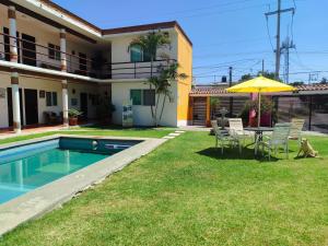 a backyard with a table and chairs and an umbrella at Hotel Villas Cuernavaca in Temixco