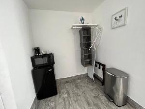 a small room with a refrigerator and a shelf at Privet Studio 10 Min To Beach - 17 in Clearwater +7 photos