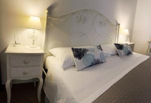 a bedroom with a white bed and a night stand at Alba b&b in Polignano a Mare