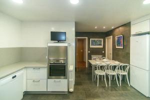 a kitchen and dining room with a table and a television at WELCS CASA 272 PDA con piscina privada in Garrigolas