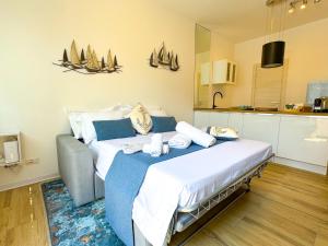 a bedroom with a large bed and a kitchen at 2 Steps by the Como Lake in Mandello del Lario