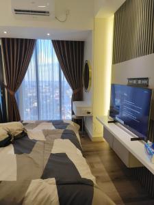 a bedroom with a bed and a flat screen tv at Pollux Habibie Batam Polux in Batam Center