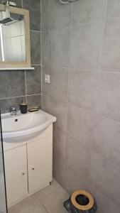 ein Badezimmer mit einem weißen Waschbecken und einem Spiegel in der Unterkunft Ground floor of villa in Brando