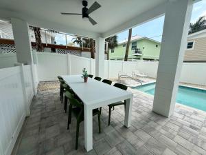 een witte tafel en stoelen op een patio met een zwembad bij New Build - Pool - Walk to Beach in Fort Myers Beach