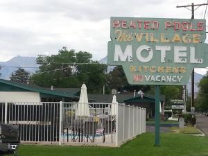 a sign for a heated poles he will large motel at Bishop Village Motel in Bishop