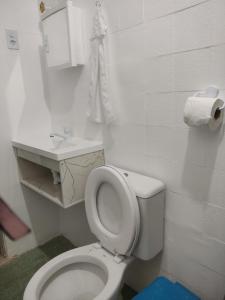 een witte badkamer met een toilet en een wastafel bij Casa próximo centro de eventos com ar condicionado in Fortaleza
