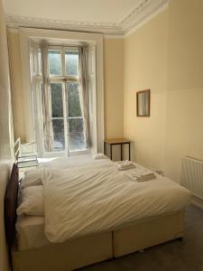 ロンドンにあるCentral London Budget Roomsの大きな窓付きのベッドルームのベッド1台