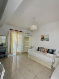 a white living room with a couch and a table at Marianna Studios in Donoussa