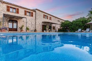 a large swimming pool in front of a building at Finca es Rafal, Agroturisme in Montuiri