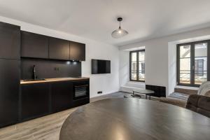 a kitchen with a table and a living room at Studio de charme rénové calme et lumineux in Thonon-les-Bains