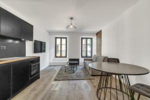 a kitchen and living room with a table and a couch at Studio de charme rénové calme et lumineux in Thonon-les-Bains