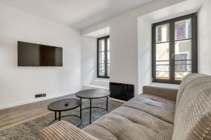 a living room with a couch and two tables at Studio de charme rénové calme et lumineux in Thonon-les-Bains
