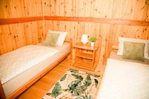 a room with two beds in a wooden cabin at Domki Letniskowe Bursztynek in Grzybowo