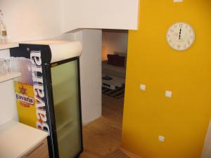 a kitchen with a yellow wall and a clock on a wall at Hostel Musala in Mostar