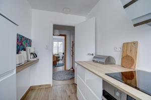 cocina con paredes blancas y encimera de madera en La Traversée Brestoise - Appartement tout confort avec parking privatif au centre-ville, en Brest